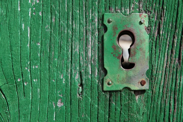 Yeşil ahşap kapıdaki eski anahtar deliği — Stok fotoğraf