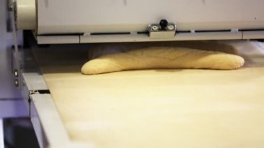 Ekmeği taşıma bandından çıkarıyorum.