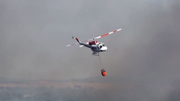 Helicóptero con depósito de agua en cámara súper lenta, vista lateral — Vídeos de Stock