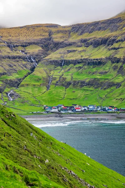 Tjornuvik village with colorful houses surrounded by green mountains in bay — Stock Photo, Image