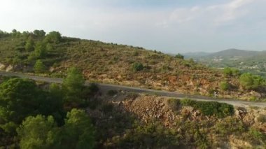 Yüksek yamaçlı dağ yolunda bisikletçinin hava manzarası