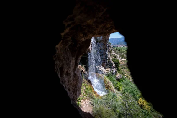 그 주위에 원문 공간이 있는 동굴을 관통하는 폭포 — 스톡 사진