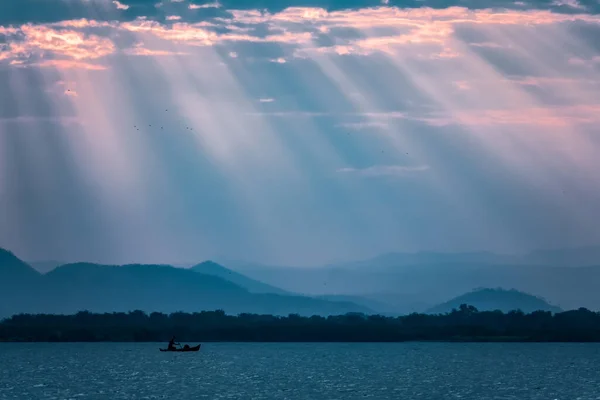 Cloudscape at sunset over lake Malawi with sun beams and fisherman — Stock Photo, Image