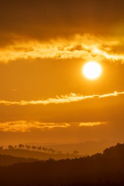 Bulutlu gökyüzü üzerinden portakal rengi gün batımı