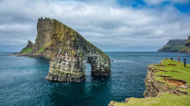 Bulanık turistlerle dolu Drangarnir kapısı Faroe Adaları