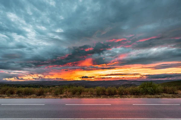 Route dans le pays spectaculaire coucher de soleil nuageux — Photo