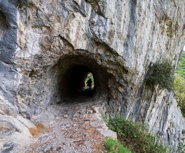 Tünel ve karanlık turistlerle kayalıklarda iz sür. — Stok fotoğraf