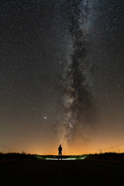 Rear view of 1 person silhouette at night with milky way