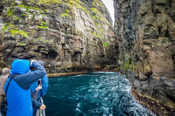 Tourists taking photos to the spectacular Vestmanna cliffs in Faroe Islands — Stock Photo, Image
