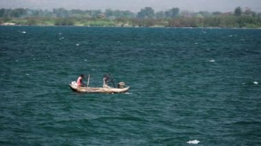 Malawi Gölü 'nde kürek çeken pikselli balıkçılar.