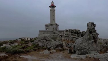 Atlantik kıyısındaki engebeli bir uçuruma tünemiş ikonik bir deniz fenerinin havadan çekim görüntüleri..
