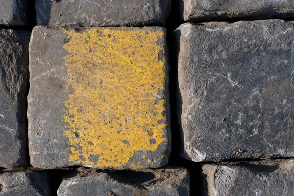 Old road tiles with yellow paint. Street, road details. Horizontal background.