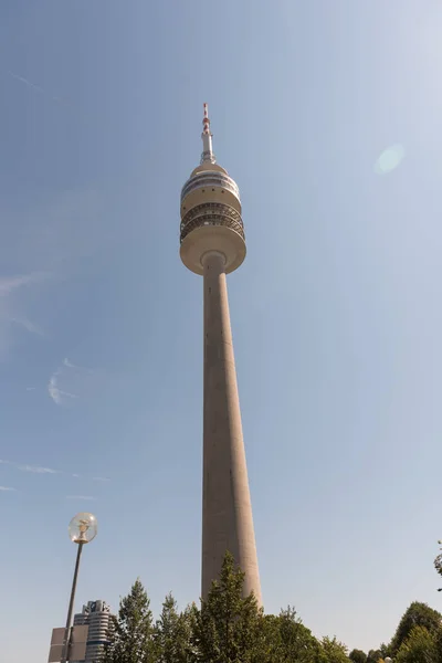 Olympic tower in Munich, Germany with white clouds and blue sky in background.