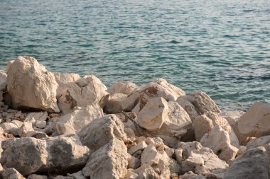 Kayalık sahil şeridi. Keskin taşlar, kayalar ile deniz suyu arka planda.