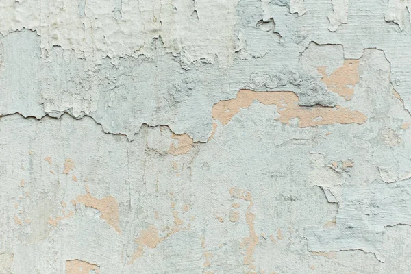 The texture of the mottled shabby wall, painted blue and gray plaster, abstract background close-up