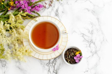 Porcelain Cup with herbal Ivan-tea with Fireweed and Meadowsweet on the marble table. Harvesting. clipart