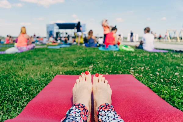 Piedi Femminili Con Unghie Rosse Tappetino Rosa Yoga Sull Erba — Foto Stock