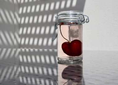 Yabani kiraz tatlı komposto yüksek bir anahtar arka plan, metin için yer ile küçük cam kavanoz içinde. Seçici ve yumuşak odak.                                