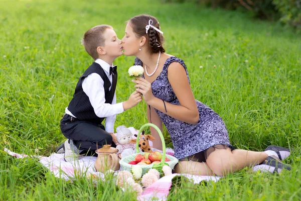 Pequeño niño y adolescente edad chica teniendo picnic al aire libre — Foto de Stock