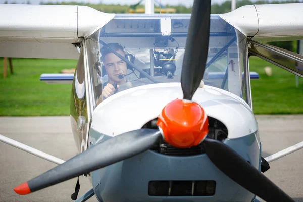 Tiro ao ar livre de homem jovem em cockpit avião pequeno — Fotografia de Stock