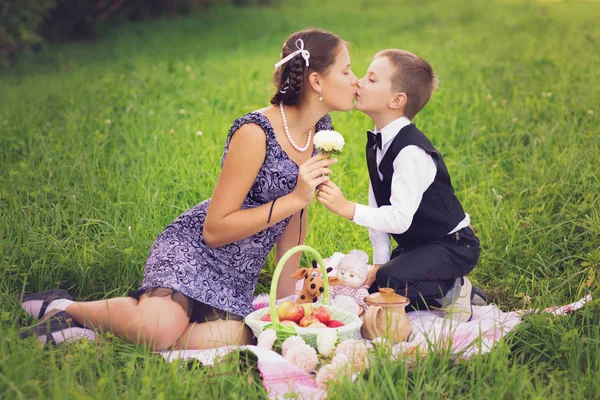 Little boy and teen age girl having picnic outdoors — Stock Photo, Image