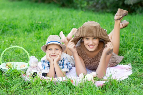 Kleine Jungen und Mädchen im Teenageralter picknicken draußen — Stockfoto