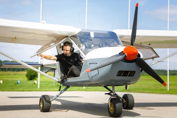 Jovem homem em pequeno avião cockpit ao ar livre — Fotografia de Stock