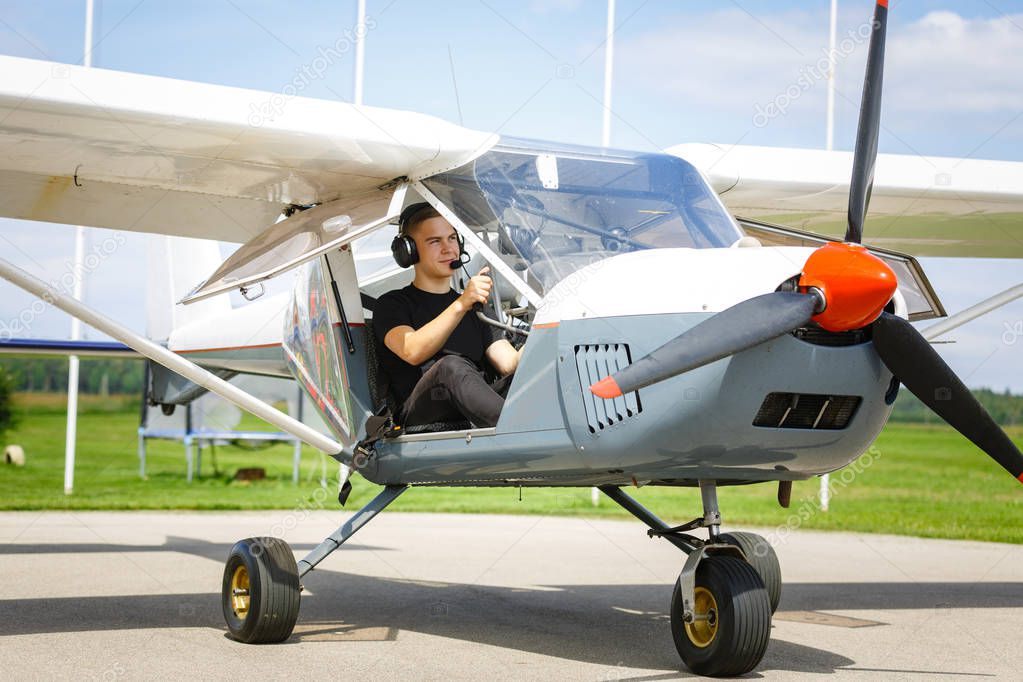 young man in small plane cockpit outdoors