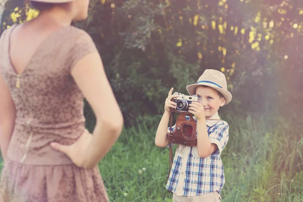 Красивый мальчик с ретро-камерой и девушкой-моделью — стоковое фото