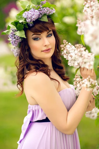 Beautiful girl in purple dress with lilac flowers — Stock Photo, Image