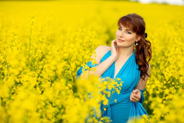 Mooi meisje in blauwe jurk met gele bloemen Stockfoto