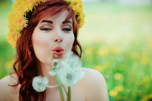 Bella ragazza con fiori di tarassaco in campo verde — Foto Stock