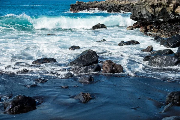 Belle vue sur l'eau de l'océan et le sable de lave noir — Photo