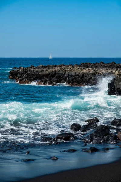 Prachtig uitzicht op de oceaanwater en zwart lava zand — Stockfoto