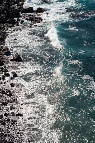 Prachtig uitzicht op de oceaanwater en zwart lava zand — Stockfoto