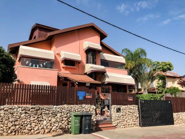 Rishon Le Zion, İsrail-30 Nisan 2018: güzel bir evin yakınında büyük ahşap ve taş çit ve büyük çiçeği renkli.