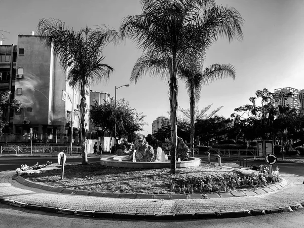 Rishon Le Zion, Israel-23 April 2018: rondellen med liten fontän på gatan med palmer i Rishon Le Zion, Israel. — Stockfoto