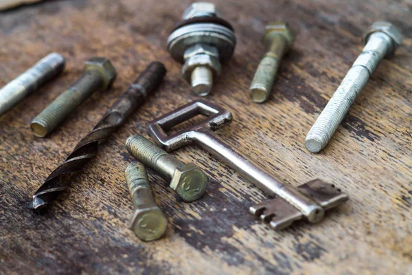 Kovové hardware s postavami rytiny na dřevěné pozadí — Stock fotografie