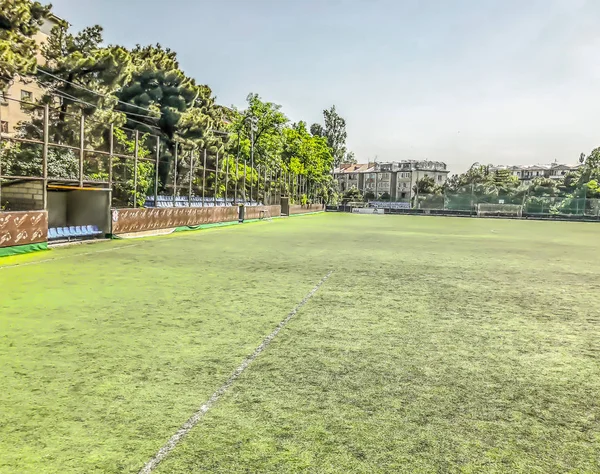 TBILISI, GEORGIA - 17 de maio de 2018: Estádio de futebol entre edifícios residenciais. Primavera na cidade . — Fotografia de Stock