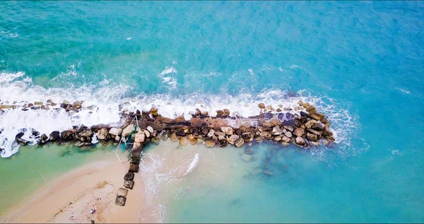 Vista aérea de las olas del mar golpeando rocas en la playa. — Foto de Stock