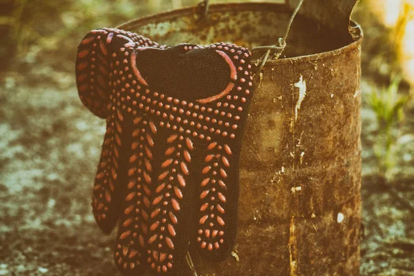 Eski bir demir varil üzerinde siyah iş eldiveni