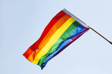 Eşcinsel bayrak mavi gökyüzü arka plan üzerinde. Büyük gökkuşağı bayrağı.