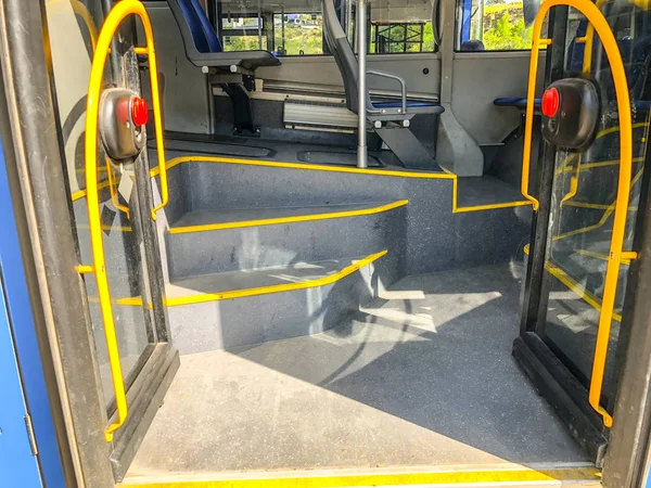 Puerta de entrada de cristal con pasamanos y escalones en el autobús urbano. Primer plano. —  Fotos de Stock