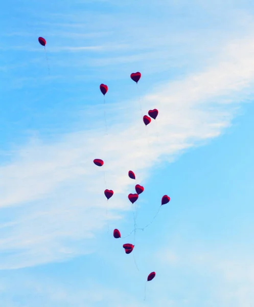 心臓の形の赤い球が青い空に飛ぶ. — ストック写真