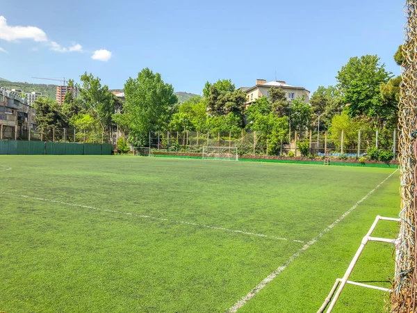 TBILISI, GEORGIA - 17 de maio de 2018: Estádio de futebol entre edifícios residenciais. Primavera na cidade . — Fotografia de Stock