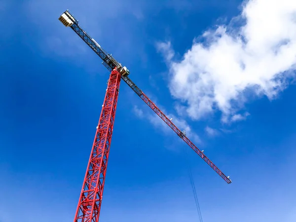 Tower building crane against the blue sky and sun. Construction of new buildings with a crane. Tower crane.