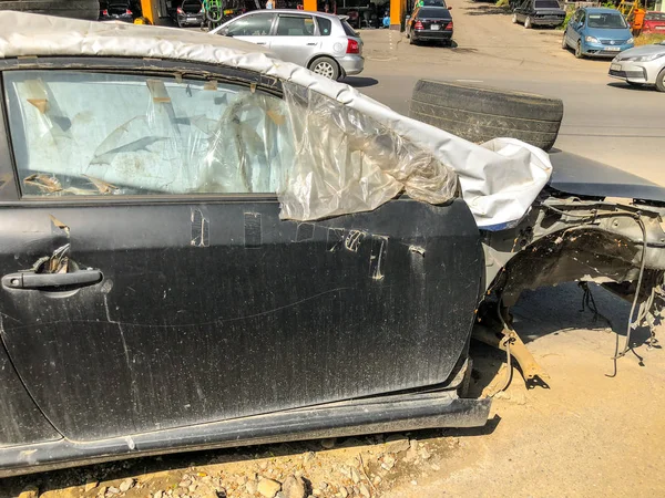 Tiflis, Gürcistan--17 Mayıs 2018: kaput lastiği ile branda ile kaplı araba kırık eski bir yola park