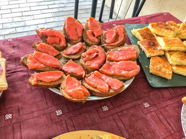 Kolację w formie bufetu w domku. Święto na charakter, Kanapki, Chaczapuri, ryby łosoś — Zdjęcie stockowe