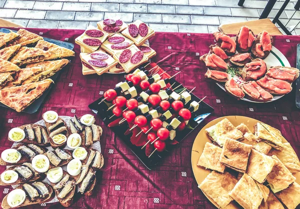 Açık büfe akşam yemeği köyünde. Doğa, sandviç, pasta et, khachapuri, balık, sebze, haşlanmış yumurta ile bayram 