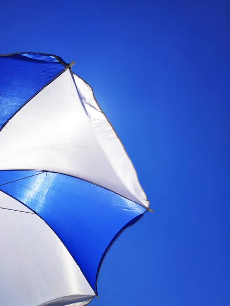 Sombrilla de Sun Beach Parasol en el día soleado en el fondo de un cielo azul que da sombra y protección — Foto de Stock